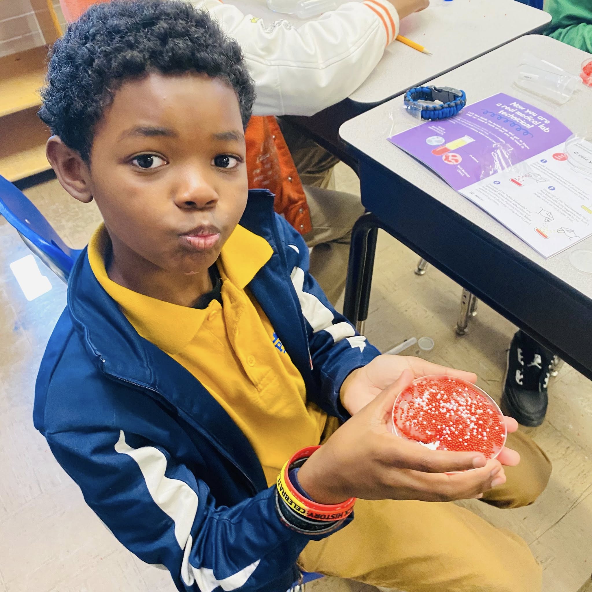 A boy holding a red blob.